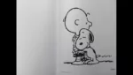 Sur la page d'un livre ouvert, un dessin signé par Schulz représente un enfant, qui reçoit un chalereux calin de la part de Snoopy, un chien bipède.