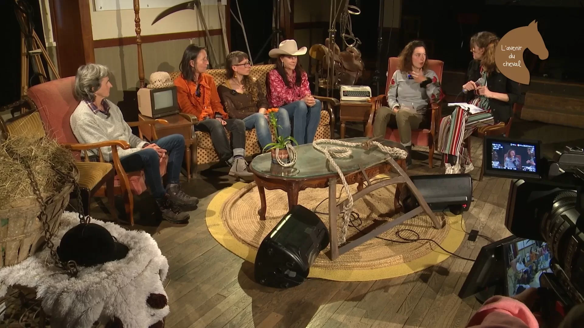 Au milieu d'un décor fleurant bon la campagne, un groupe de 6 femmes assises autour d'une table basse discutent. L'une d'elles porte un chapeau de cow-girl.